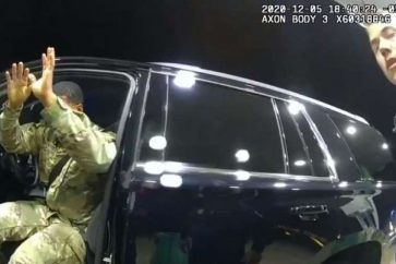 Deux policiers braquent leur arme sur le militaire noir, Caron Nazario, et arrosent son visage de gaz asphyxiant