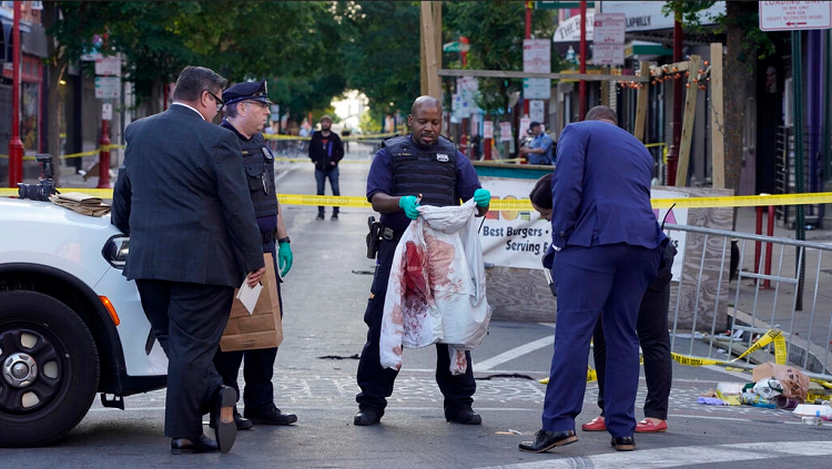 Des inspecteurs de police sur la scène de crime de South Street, à Philadelphie, le 5 juin 2022. © Michael Perez, AP