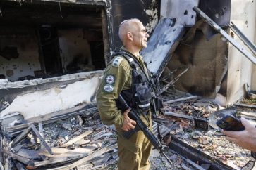 Le colonel israélien Golan Vach se tient devant une maison du kibboutz Be'eri le 14 octobre 2023, dans laquelle il a faussement affirmé que huit bébés brûlés avaient été retrouvés le 7 octobre 2023.