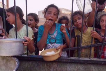 Des Palestiniens font la queue pour obtenir des rations de nourriture cuite dans un camp de réfugiés improvisé à Khan Younis, dans la bande de Gaza, le 3 septembre 2024. © AFP