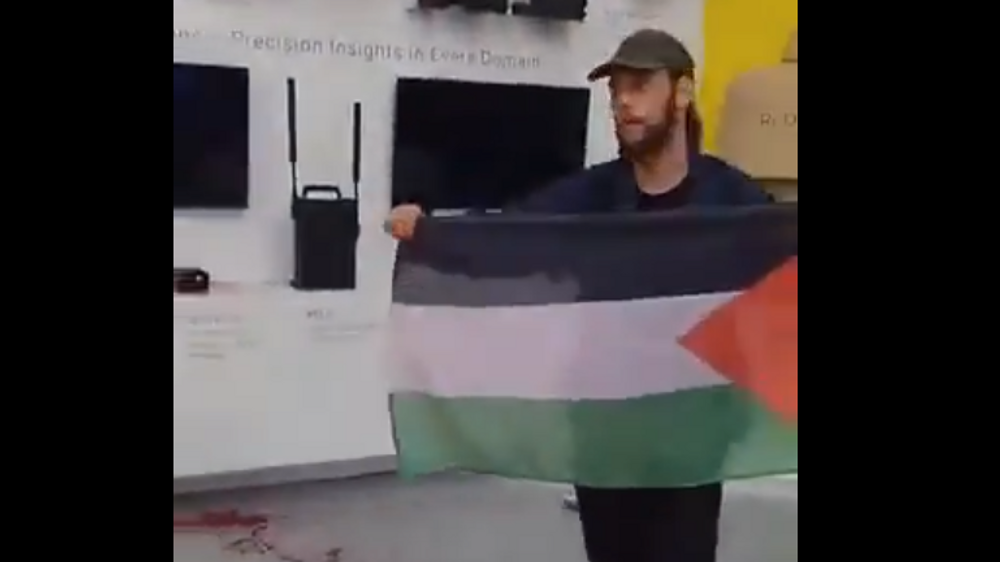 Des activistes déversent du faux sang et brandissent le drapeau palestinien devant le stand du groupe d’armement israélien Elbit Systems à Kielce, dans le sud de la Pologne.