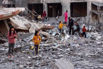 Des enfants marchent à travers les débris et les décombres sur le site d'un bombardement israélien dans un bloc résidentiel de la rue Jalaa à Gaza, le 14 janvier 2025. ©AFP